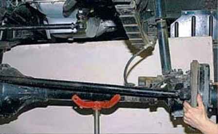 Desmontaje de la conexión del pivote y extracción del eje delantero del vehículo UAZ